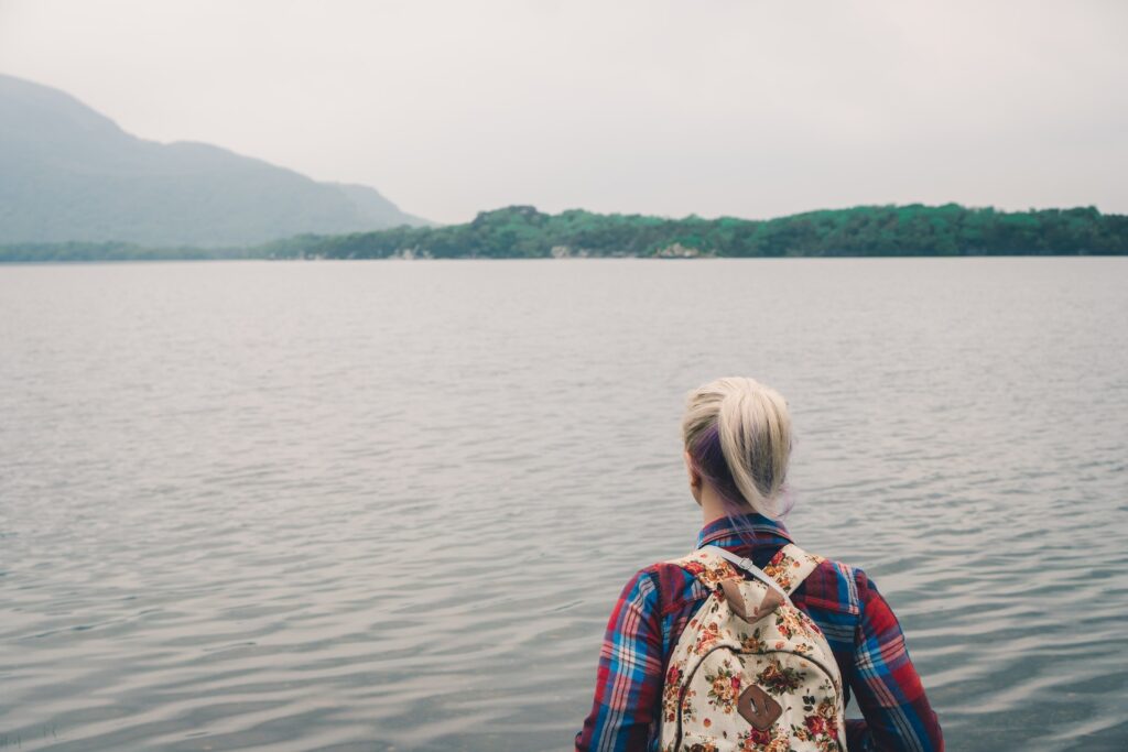 A lady looking at the lake and mountains ahead