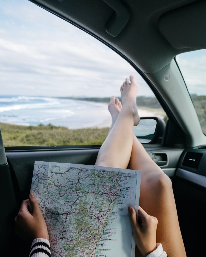 A person holding a map with legs outside the window